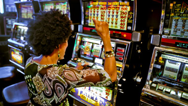 woman celebrating after winning at a casino slot machine
